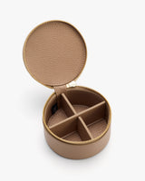 Round jewelry case with open lid and four compartments.