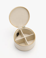 Round jewelry case with open lid and compartments inside.