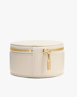 Round jewelry case with zipper and small tab.