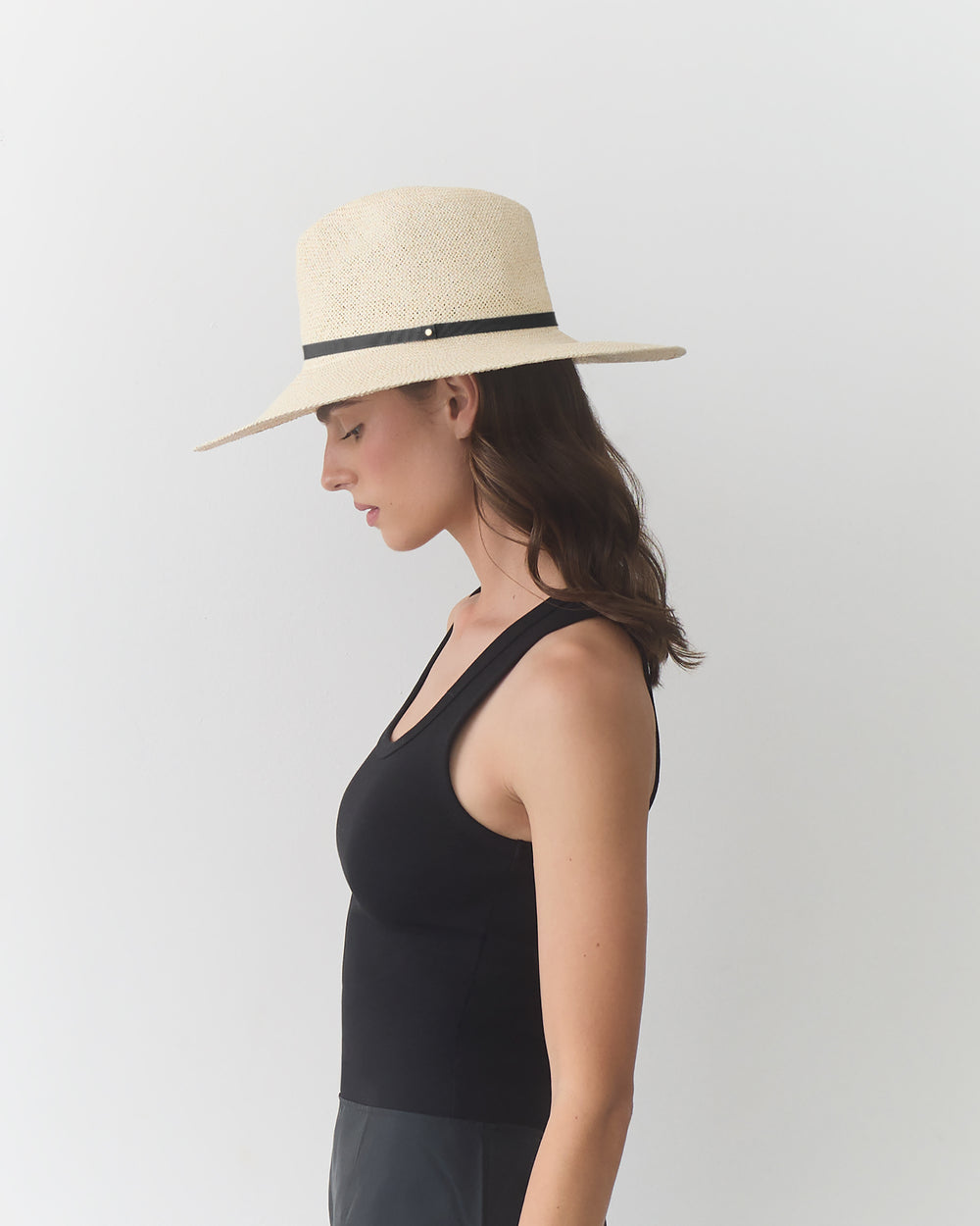 Person wearing wide-brimmed hat and sleeveless top, facing left.