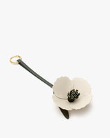 Flower-shaped leather keychain with petal details.