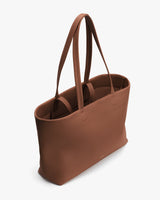 Tote bag with two long handles and open top seen from an angle.