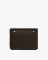 Rectangular leather clutch with two metallic studs on top.