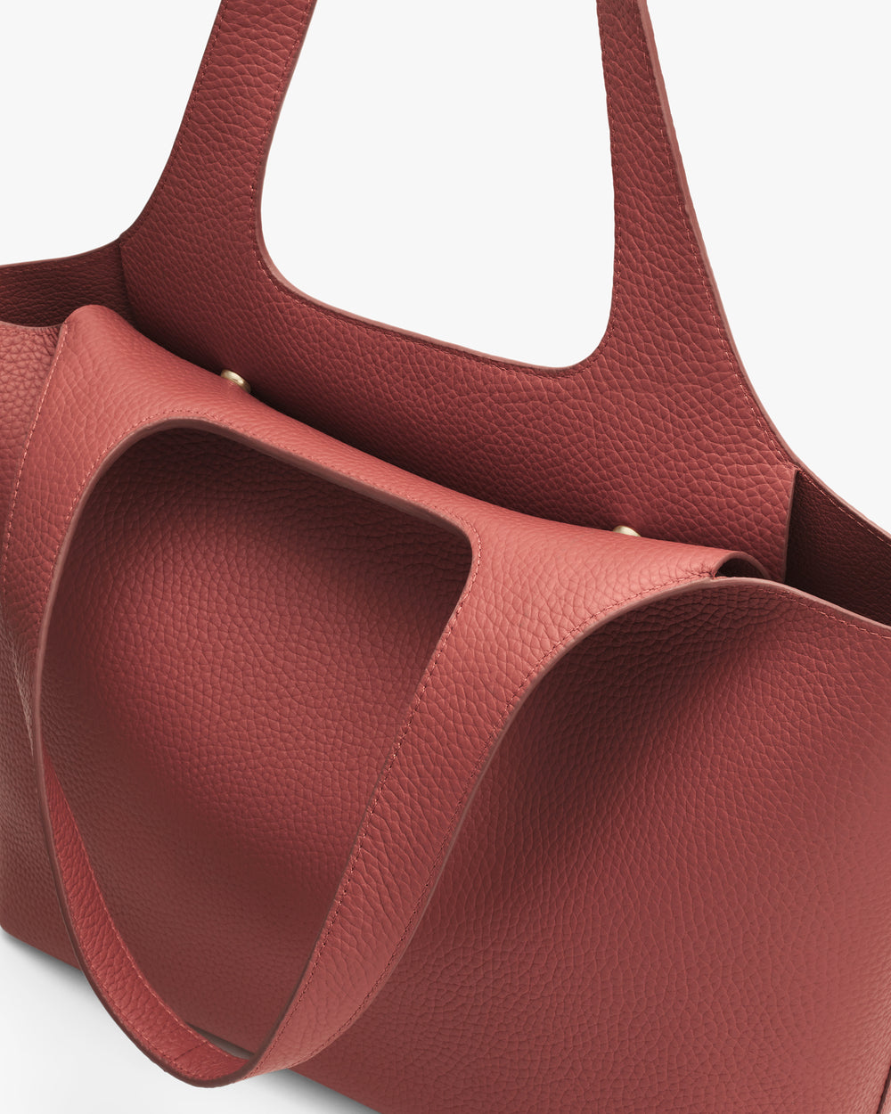 Leather tote bag with curvy design and shoulder straps.