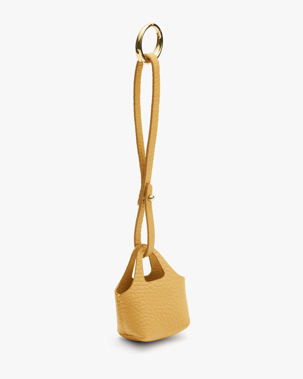 Small textured handbag with a long strap and circular metal handle.
