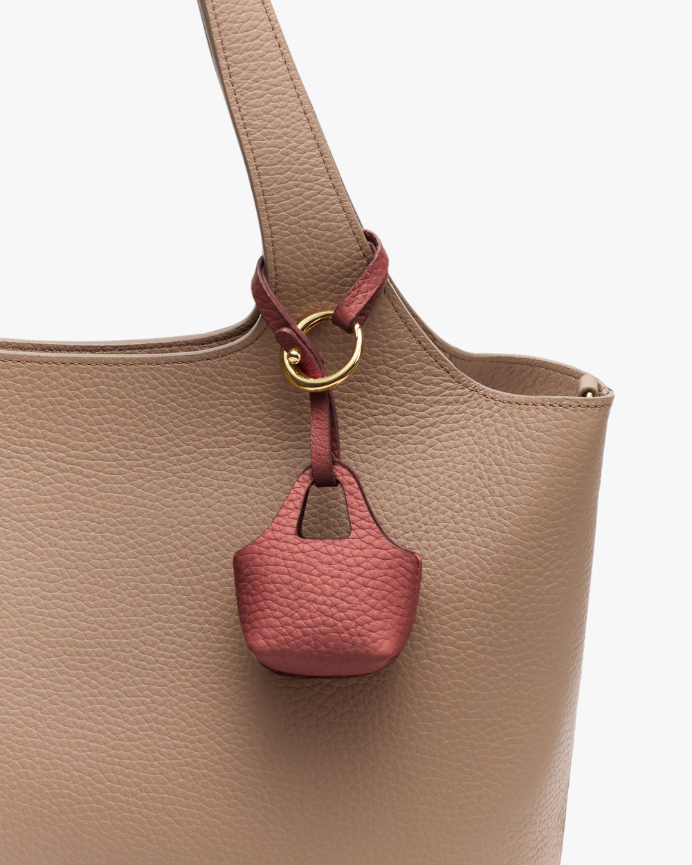 Tote bag with small textured charm attached.
