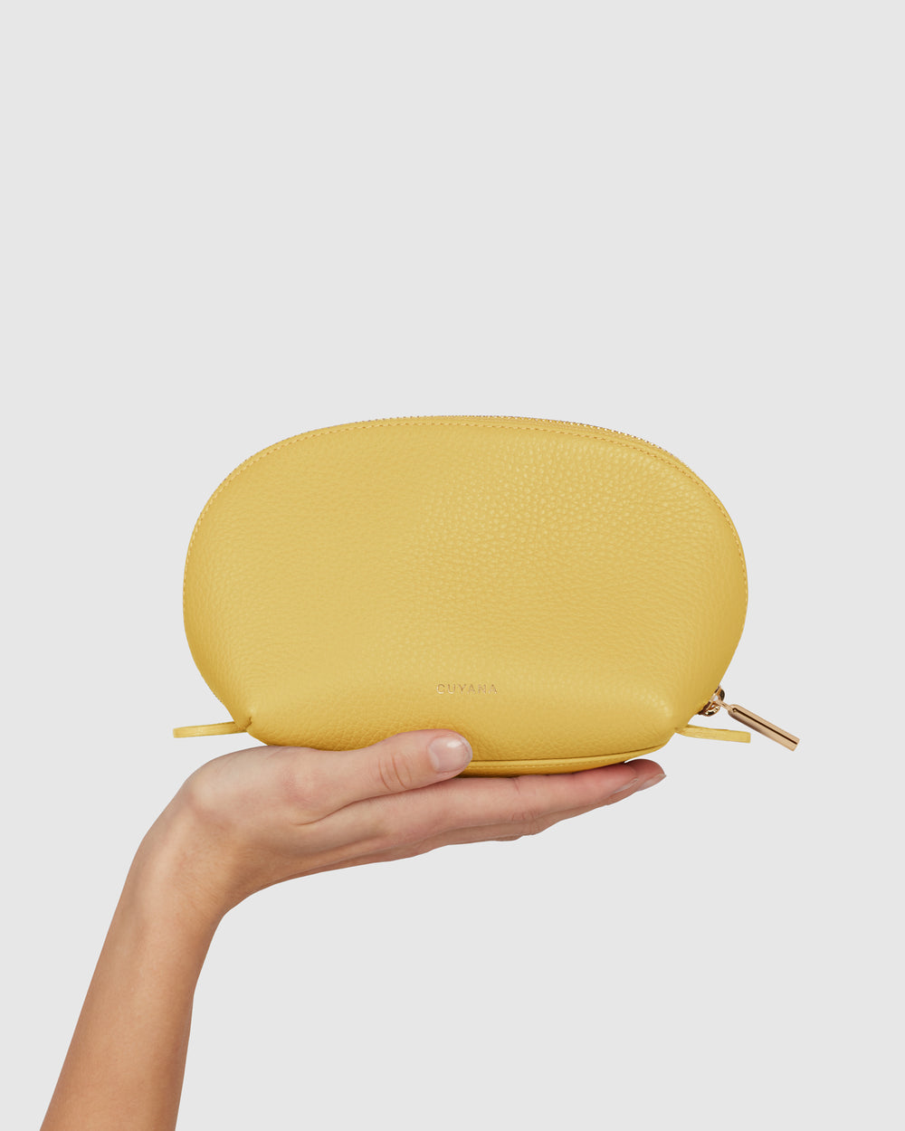 Person holds a small pouch in one hand.