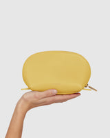 Person holds a small pouch in one hand.