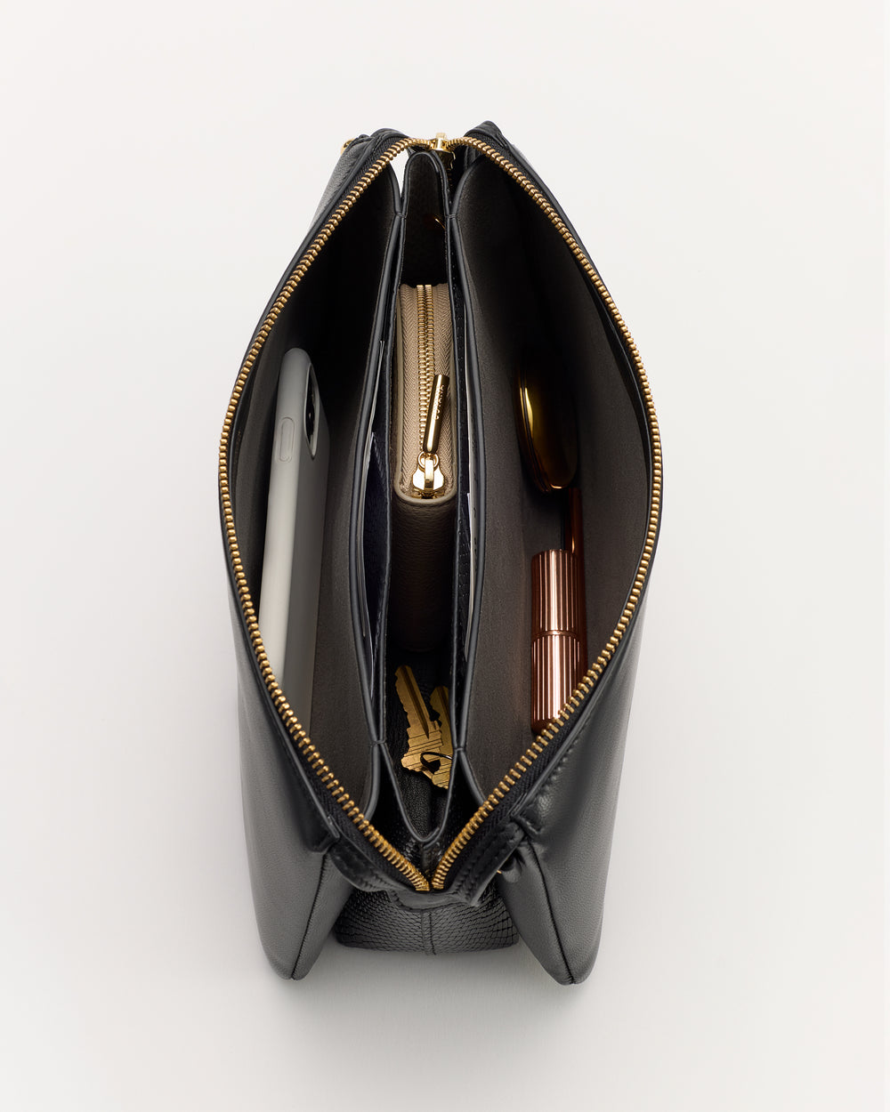 Open handbag with items including a phone, pouch, and lipstick inside.