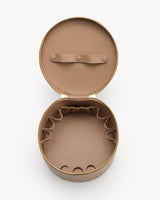 Round open container with zipper, elastic pockets, and buttoned strap inside.