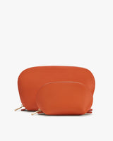 Two orange pouches with zippers, one larger and one smaller, placed together.