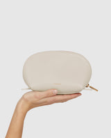 Hand holding a small pouch with zipper.