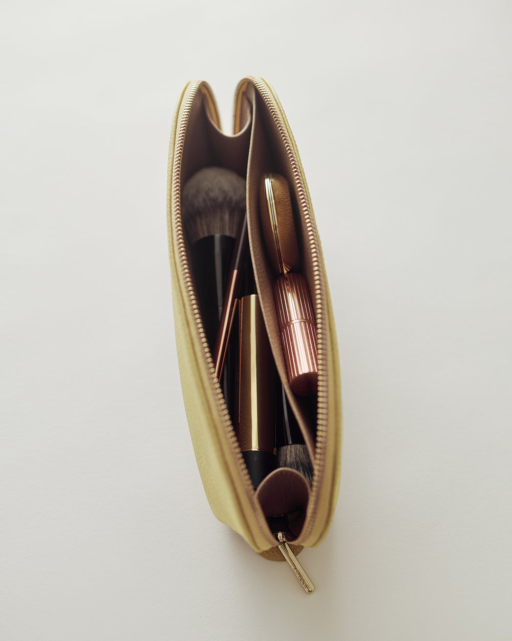 Makeup case containing brushes and lipstick, view from above.