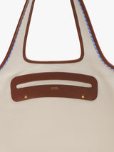 Tote bag with cut-out handle and stitching detail.