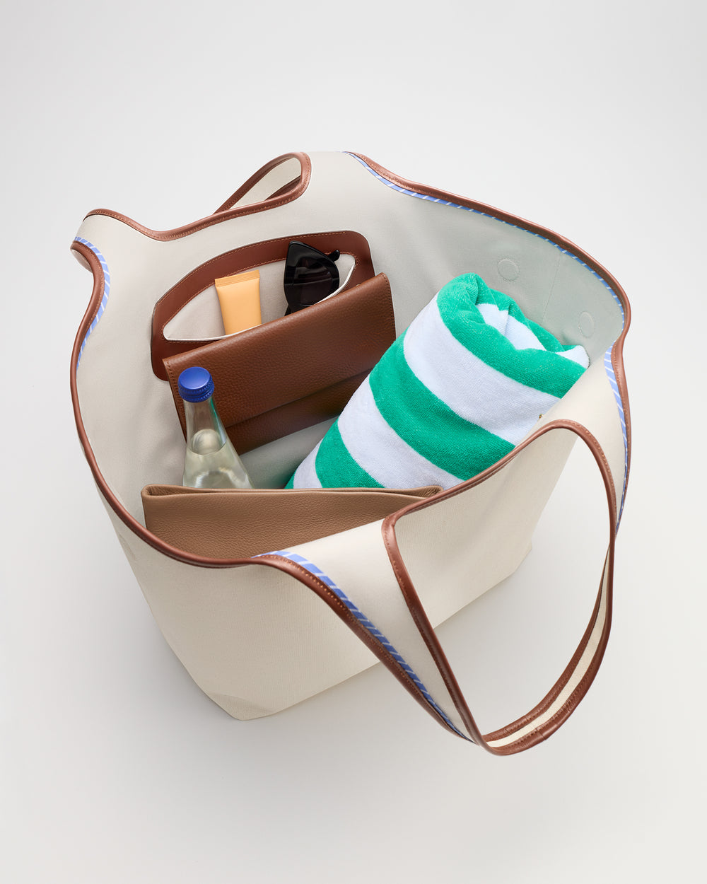Open tote bag with a towel, bottle, and various items inside.