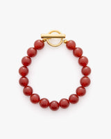 Beaded bracelet with round beads and a circular clasp.