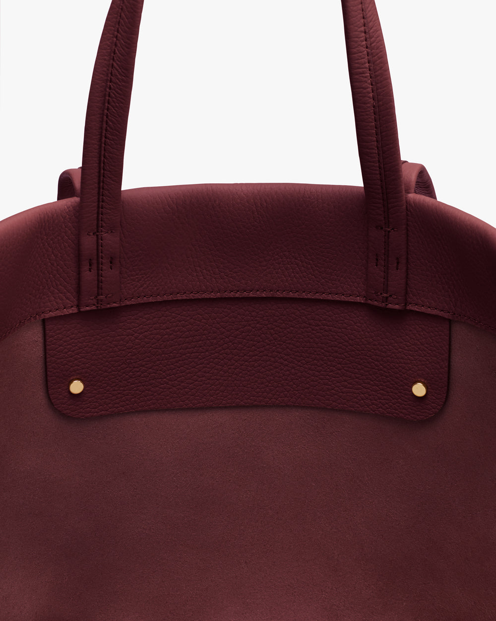 Close-up of a tote bag with two handles and metal accents.