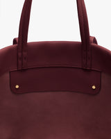 Close-up of a tote bag with two handles and metal accents.