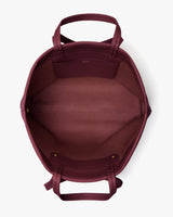 Open travel bag with handles, showing its empty interior and pocket.