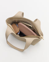 Open handbag displaying wallet, sunglasses, and pouch inside.