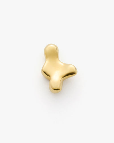 Abstract gold metal object on plain background.