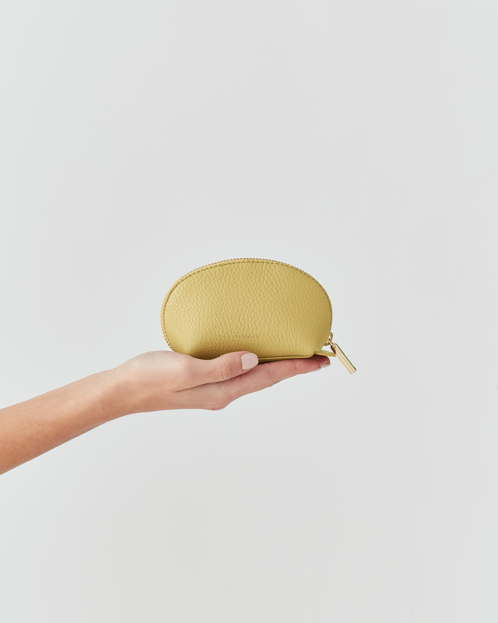 Hand holding a small zippered pouch.