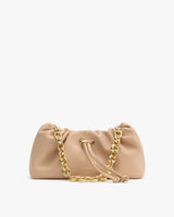 Handbag with chain strap and drawstring closure on display