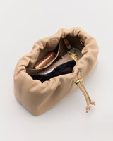 Open drawstring bag with sunglasses, wallet, and lipstick inside.