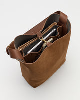 Open handbag showing organized compartments and electronic devices inside.