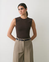 Person wearing sleeveless top and wide-leg pants with belt.