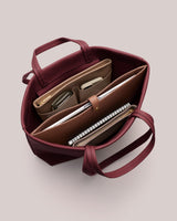 Open handbag with organized pockets and items inside.