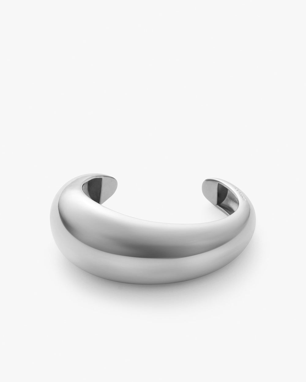 Metallic bracelet with open ends on a plain background