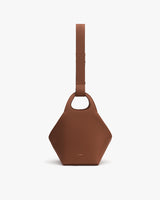 Geometric-shaped handbag with wide strap and top handle.