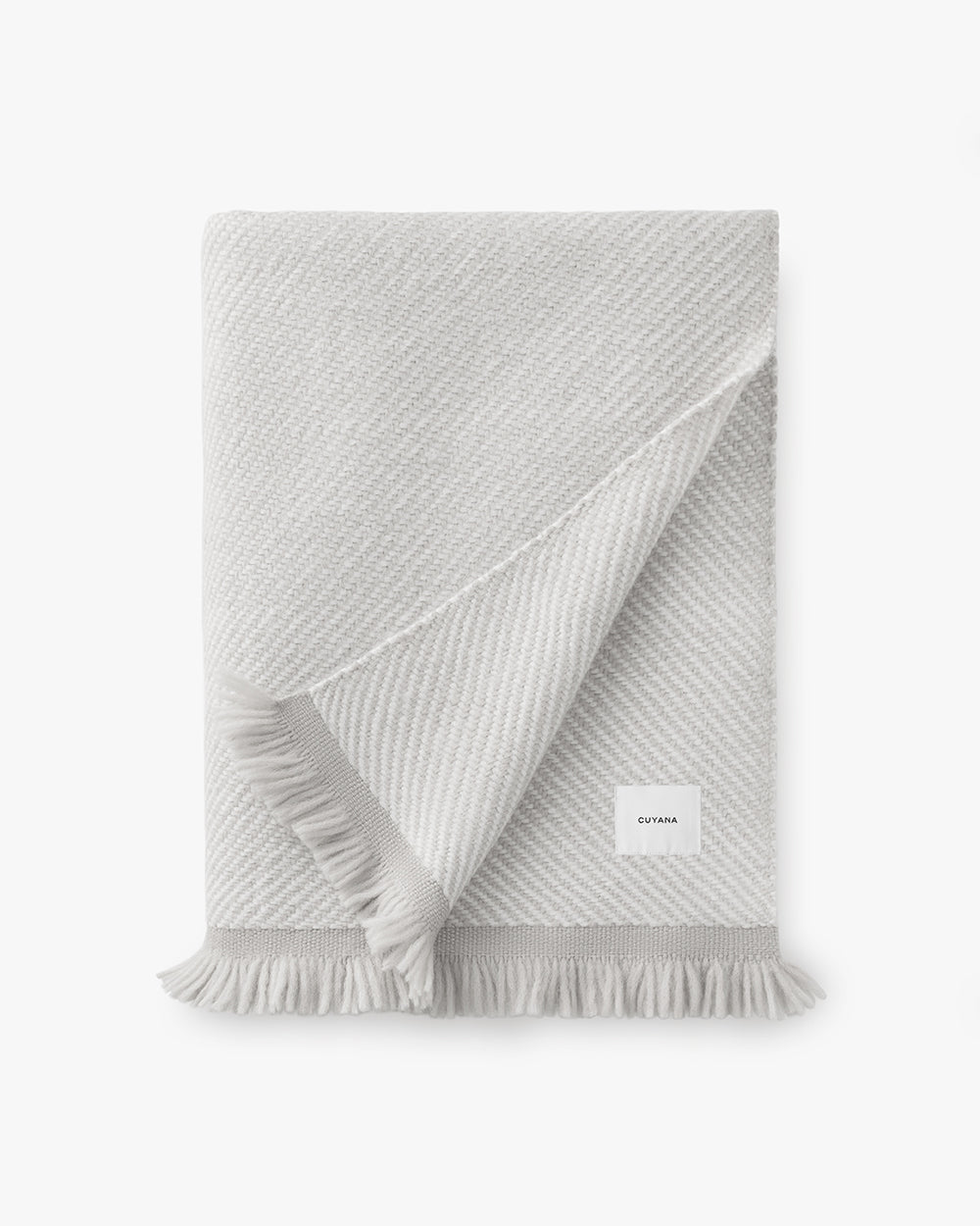 Folded fringed blanket with visible label.