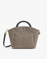 Handbag with top handles and shoulder strap, standing upright.