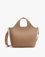 Tote bag with a shoulder strap and cutout handles.