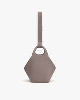 Geometric handbag with wide strap and circular handle.