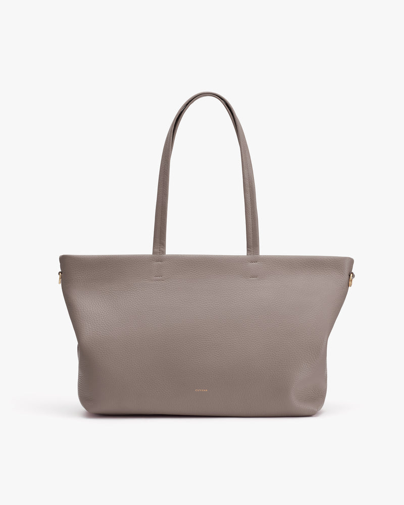 Tote bag with long handles on plain background.