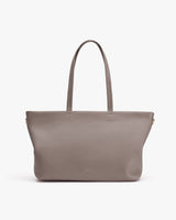 Tote bag with long handles on plain background.