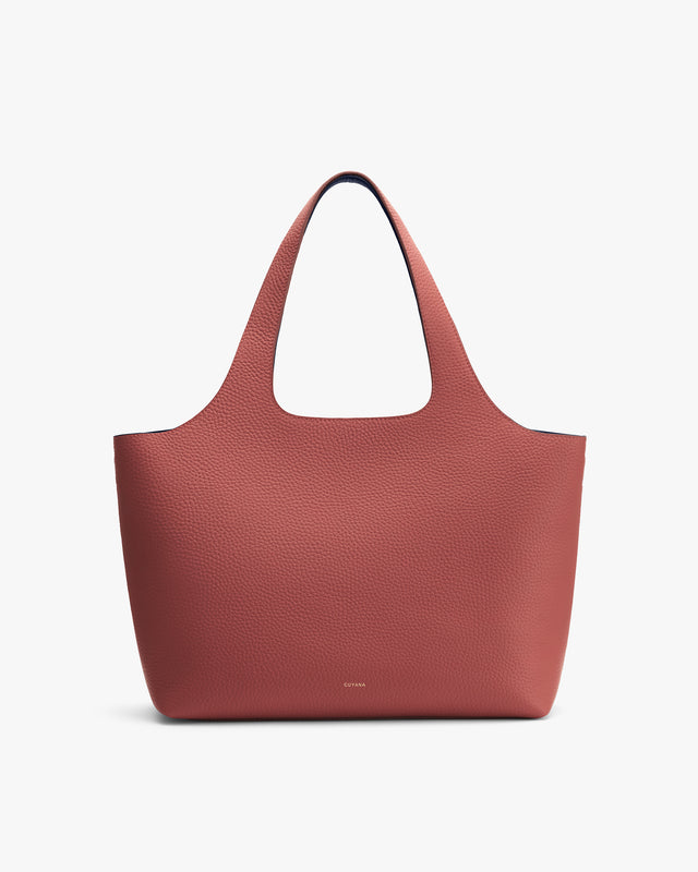 Tote bag with pebbled texture and wide handles.
