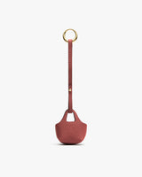Small textured pouch with a long strap and circular metal ring.