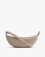 Half moon shaped crossbody bag with adjustable strap and gold-tone hardware.