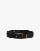 Leather belt with gold buckle on display.