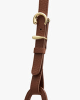 Close-up of a textured leather strap with metal buckle detail
