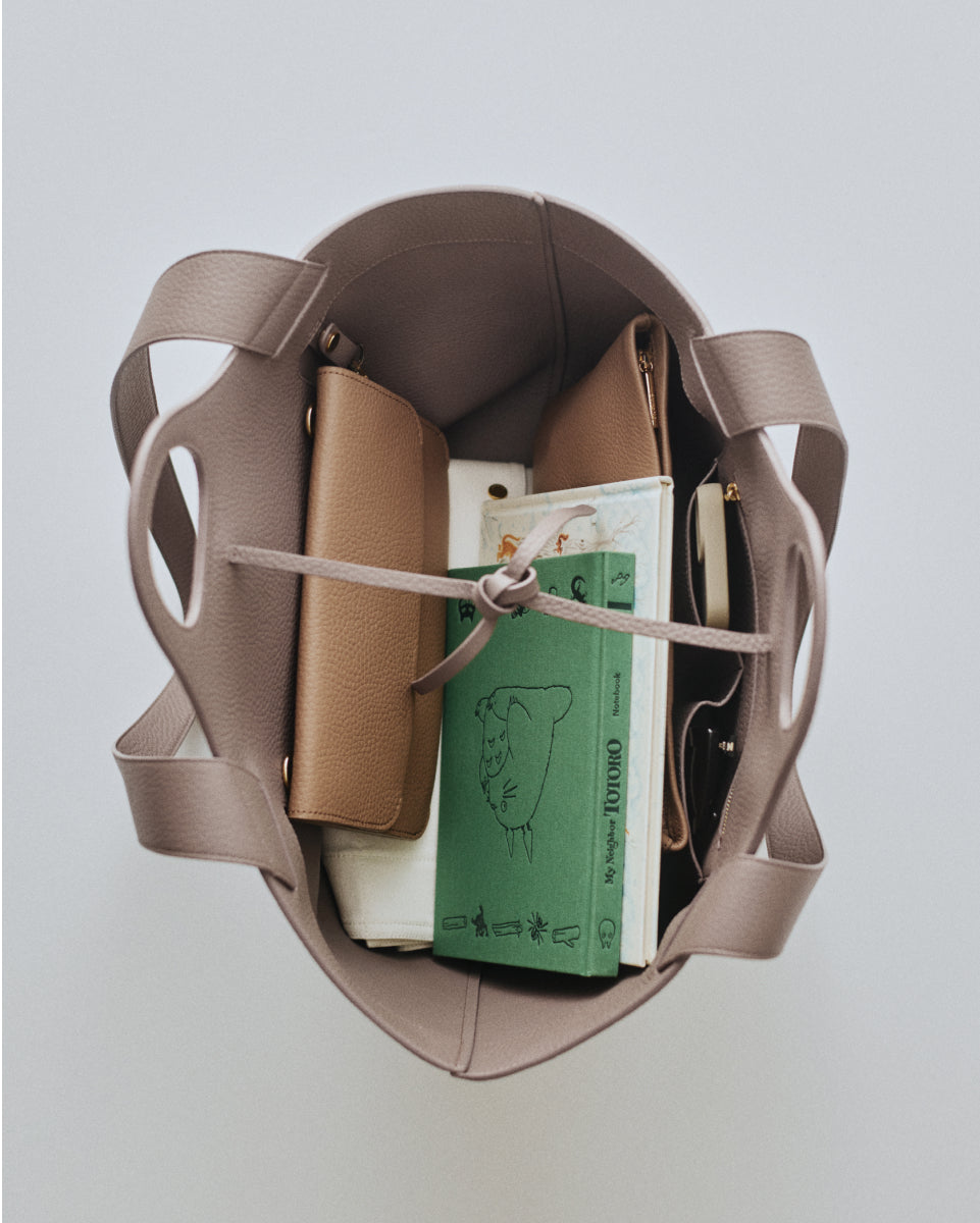 Open handbag with books and pouches inside.