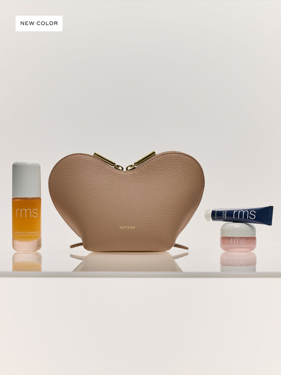 Heart-shaped pouch with three cosmetic items placed beside it.