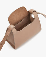 Open handbag with adjustable strap and flap open.