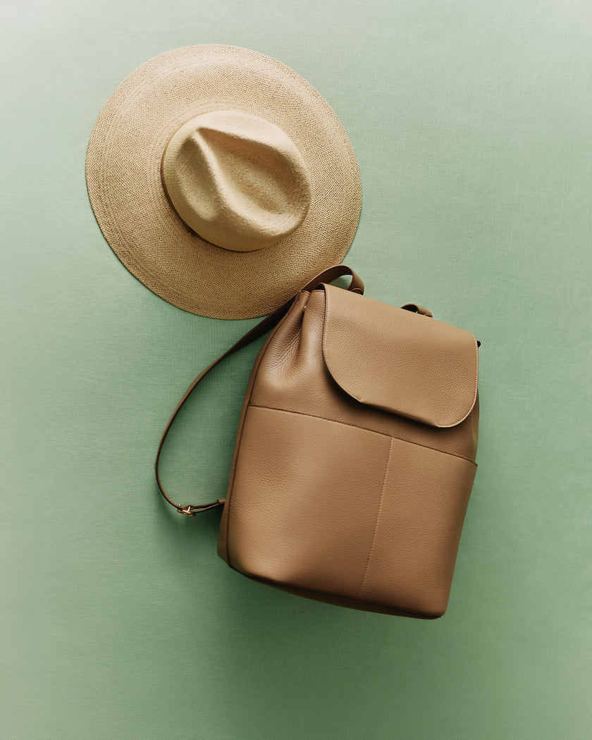 Wide-brimmed hat and backpack on a flat surface