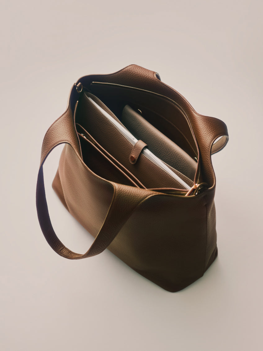 Open handbag with a laptop and notebook inside.