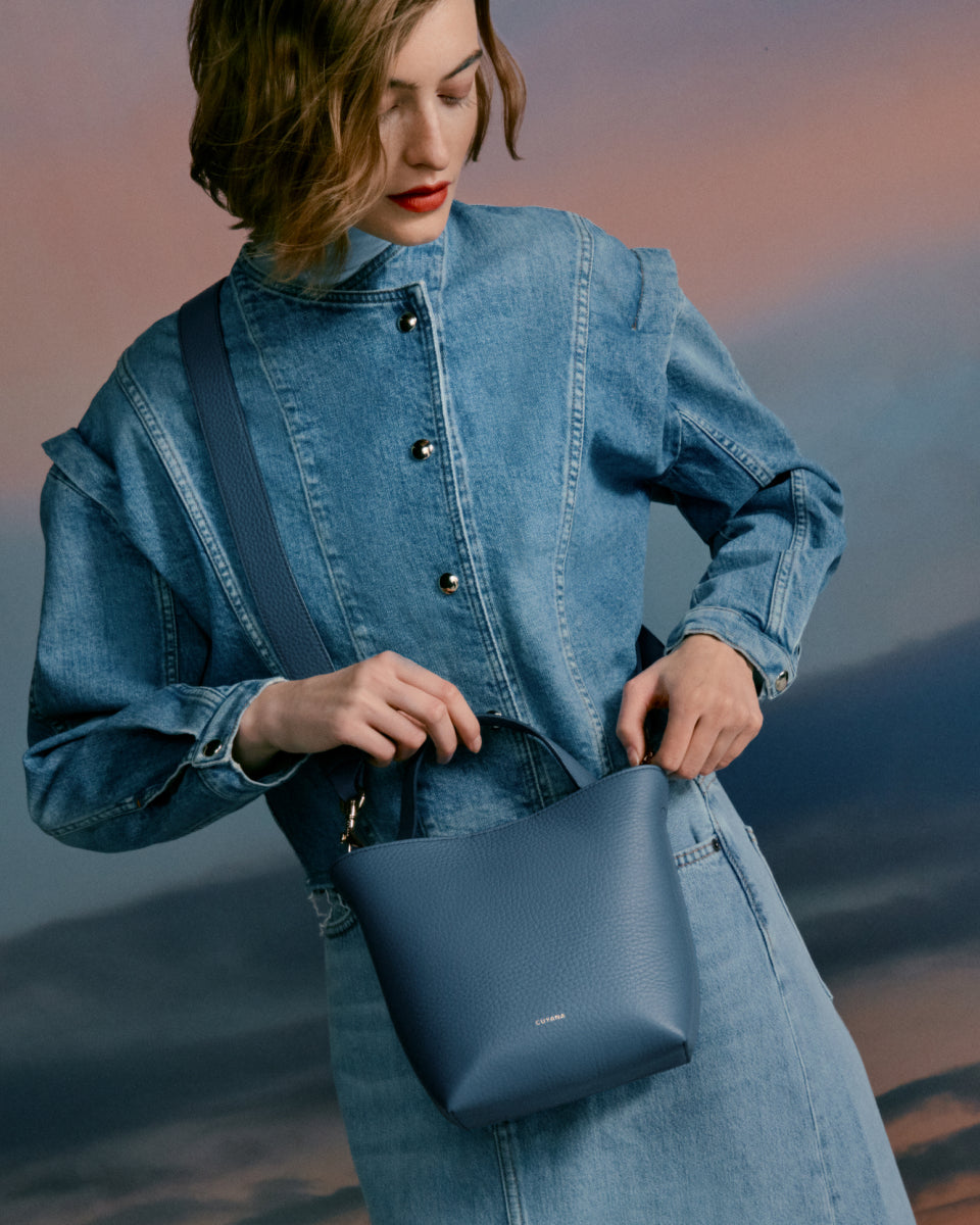 Woman in denim outfit holding a handbag